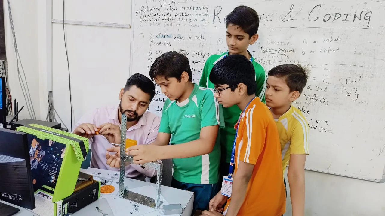 Primary school students assembling electronic robotics kits